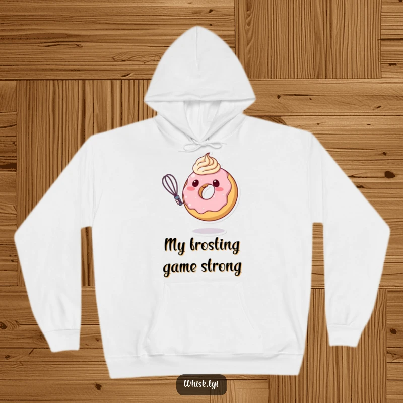 Funny donut character artistically swirling thick frosting with a whisk, featured on a cozy hoodie, radiating warmth and sweet, playful energy.