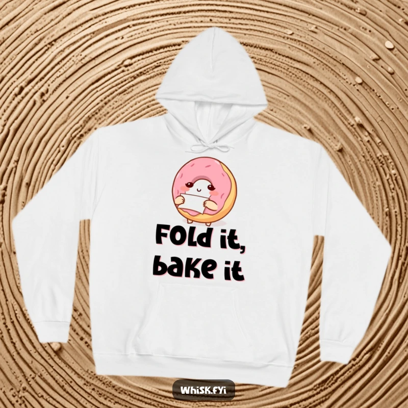 Funny, determined donut character carefully folding parchment paper, depicted on a cozy hoodie for meticulous bakers.